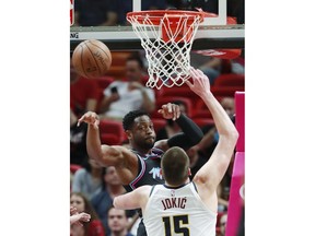 Miami Heat guard Dwyane Wade, rear, passes past Denver Nuggets center Nikola Jokic (15) during the first half of an NBA basketball game, Tuesday, Jan. 8, 2019, in Miami.