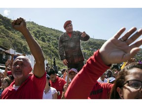 Government supporters hold a life-size image of Venezuela's late President Hugo Chavez during a rally in La Guaira, Venezuela, Friday, Jan. 25, 2019. Venezuelan President Nicolas Maduro, Chavez's protege, says he's willing to engage in talks with the opposition in order to avoid violence in a conflict over who is the legitimate leader of the country.