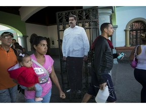 A cardboard life-size cut out of Venezuelan President Nicolas Maduro stands at the entrance of a public park in Caracas, Venezuela, Friday, Jan. 25, 2019. Juan Guaido, the Venezuelan opposition leader who has declared himself interim president, appeared in public Friday for the first time in days and vowed to remain on the streets to usher in a transitional government, while President Nicolas Maduro dug in and accused his opponents of orchestrating a coup.