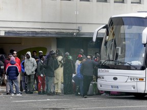 Migrants wait to board a bus to leave the Castelnuovo di Porto migrants center, some 10 kilometers north of Rome, Wednesday, Jan. 23, 2019. Migrants are being transferred following the decision to close Italy's second largest state-run reception center.