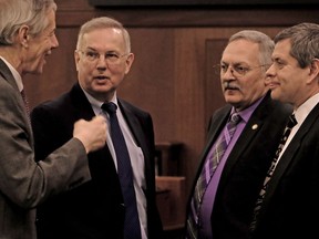 Members of the Alaska state House of Representatives, Matt Claman, from left, of Anchorage, Bryce Edgmon of Dillingham, Dave Talerico of Healy and Chris Tuck of Anchorage speak together during the floor session at the Capitol Tuesday, Jan. 22, 2019, in Juneau, Alaska. Even though the House does not have an organized majority, members adjusted rules to accept Gov. Mike Dunleavy's request to hold the State of the State address Tuesday evening.