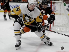 Pittsburgh Penguins left wing Jake Guentzel, left, vies for the puck against Anaheim Ducks defenseman Brandon Montourn during the first period of an NHL hockey game in Anaheim, Calif., Friday, Jan. 11, 2019.