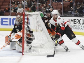 Ottawa Senators' Chris Tierney (71) skates around the goal for a shot as Anaheim Ducks' Jake Dotchin, center, chases during the first period of an NHL hockey game Wednesday, Jan. 9, 2019, in Anaheim, Calif.