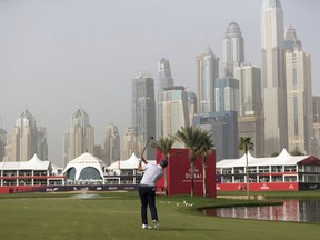 Lee Westwood of Britain hits an approach shot onto the green at the 18th hole during the round one of the Dubai Desert Classic golf tournament in Dubai, United Arab Emirates, Thursday, Jan. 24, 2019.