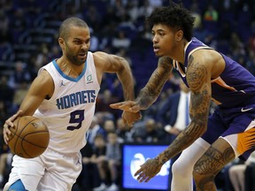 Charlotte Hornets guard Tony Parker (9) drives past Phoenix Suns forward Kelly Oubre Jr. in the first half during an NBA basketball game, Sunday, Jan. 6, 2019, in Phoenix.