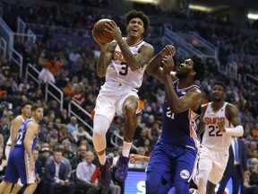 Phoenix Suns forward Kelly Oubre Jr. (3) drives past Philadelphia 76ers center Joel Embiid (21) in the first half during an NBA basketball game, Wednesday, Jan. 2, 2019, in Phoenix.