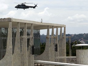An army helicopter flies over Planalto Presidential palace, during security preparations for Tuesday's inauguration ceremony of Brazil's President-elect Jair Bolsonaro, in Brasília, Brazil, Monday, Dec. 31, 2018. The Secretary of Public Security in Brasilia said that they are expecting as many as 500,000 people to attend the ceremony.