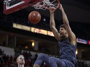 Nevada's Trey Porter, right, dunks over Fresno State's Sam Bittner during the first half of an NCAA college basketball game in Fresno, Calif., Saturday, Jan. 12, 2019.