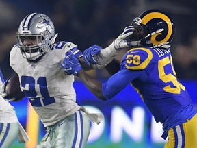 Dallas Cowboys running back Ezekiel Elliott pushes off Los Angeles Rams inside linebacker Cory Littleton during the first half in an NFL divisional football playoff game Saturday, Jan. 12, 2019, in Los Angeles.