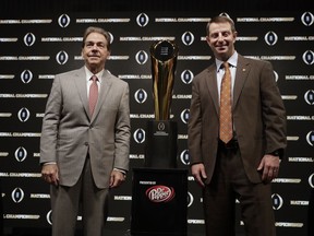 Alabama head coach Nick Saban and Clemson head coach Dabo Swinney pose with the trophy at a news conference for the NCAA college football playoff championship game Sunday, Jan. 6, 2019, in Santa Clara, Calif.