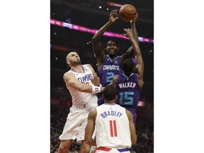 Charlotte Hornets' Marvin Williams (2) grabs a rebound over teammate Kemba Walker (15) and Los Angeles Clippers' Marcin Gortat, left, during the first half of an NBA basketball game Tuesday, Jan. 8, 2019, in Los Angeles.