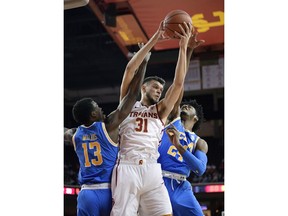 Southern California forward Nick Rakocevic, center, grabs a rebound away from UCLA guard Kris Wilkes, left, and guard Jalen Hill during the first half of an NCAA college basketball game Saturday, Jan. 19, 2019, in Los Angeles.