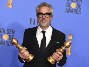 Alfonso Cuaron poses in the press room with the awards for best director, motion picture and best motion picture, foreign language for "Roma" at the 76th annual Golden Globe Awards at the Beverly Hilton Hotel on Sunday, Jan. 6, 2019, in Beverly Hills, Calif.