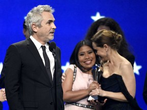Alfonso Cuaron, from left, accepts the award for best picture for "Roma" as Yalitza Aparicio and Marina De Tavira react at the 24th annual Critics' Choice Awards on Sunday, Jan. 13, 2019, at the Barker Hangar in Santa Monica, Calif.