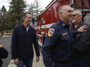 Gov. Gavin Newsom, left, is escorted by Thom Porter, right, to the California Department of Forestry and Fire Protection CalFire Colfax Station Tuesday, Jan. 8, 2019, in Colfax, Calif. On his first full day as governor, Newsom announced executive actions to improve the state's response to wildfires and other emergencies. Earlier Newsom appointed Porter, to head the state's firefighting agency.