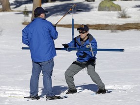 Department of Water Resources Water Resource Engineer John King, right, places the snow survey tube to on a scale held by DWR State Climatologist Dr. Michael Anderson, left , during the first snow survey of the season at Phillips Station, Thursday, Jan. 3, 2019, near Echo Summit, Calif.  California water managers said Thursday the Sierra snowpack is only 67 percent of normal in this winter's first manual measurement. Winter snow in the Sierra provides drinking water for much of California as it melts in the spring and summer and flows into reservoirs for storage.