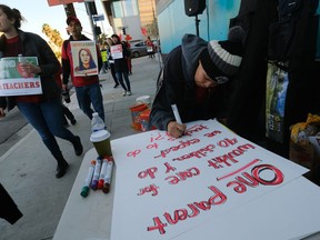 Rosa Companioni prepares a rally sign in support of Los Angeles school teachers Tuesday, Jan. 22, 2019, in Los Angeles.  A strike by thousands of Los Angeles school teachers entered its second week Tuesday following a long weekend of marathon contract bargaining, and officials on both sides of the dispute planned to issue an update on where the talks stand.
