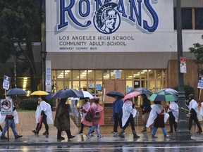 Los Angeles Unified District teacher brave the pouring rain to join in a picket line during a citywide teacher strike in front of Los Angeles High School on Monday, Jan. 14, 2019. Tens of thousands of Los Angeles teachers went on strike Monday after contentious contract negotiations failed in the nation's second-largest school district.