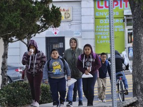 Gabriela Mota accompanies her children to school to the Evelyn Thurman Gratts Elementary School in downtown Los Angeles, Wednesday, Jan. 23, 2019, following a city wide teachers' strike. Tens of thousands of Los Angeles teachers returned to work Wednesday after voting to ratify a contract deal between their union and school officials, ending a six-day strike at the nation's second-largest district.