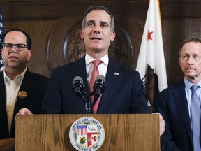 FILE - In this Tuesday, Jan. 22, 2019 file photo Los Angeles Mayor Eric Garcetti, center flanked by Austin Beutner, Superintendent of the Los Angeles Unified School District, right, and United Teachers Los Angeles, Union President Alex Caputo-Pearl, left, during a news conference at City Hall in downtown Los Angeles. While Washington remains hobbled by a shutdown and deep partisanship, Garcetti says the resolution of a teachers strike shows that government can bridge divides and bring improvements to schools. "It's a national model for what we can do," says Garcetti, who plans to soon decide if he will enter the 2020 White House contest.