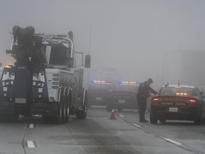 Heavy tow trucks arrive to remove trucks following a multi-car collision along foggy Interstate 15 in the Cajon Pass near Hesperia Calif., Wednesday Jan. 16, 2019.