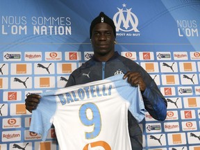 Olympique Marseille's new player Mario Balotelli poses with his new jersey during a press conference, at the club's headquarters of La Commanderie, in Marseille, southern France , Wednesday, Jan. 23, 2019.