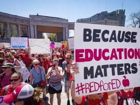 FILE - In this April 27, 2018 file photo a sign reads "Because education matters, #redfored" as thousands of teachers and supporters begin their rally from the amphitheater at Civic Center Park in Denver. After massive walkouts over teacher salaries and school funding inspired many teachers to run for office, the reality of November's results are coming into focus.