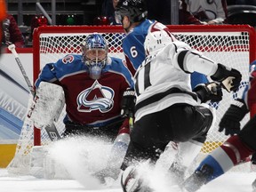 Colorado Avalanche goaltender Semyon Varlamov, left, stop a shot as the puck goes past defenseman Erik Johnson off the stick of Los Angeles Kings center Anze Kopitar in the first period of an NHL hockey game Saturday, Jan. 19, 2019, in Denver.