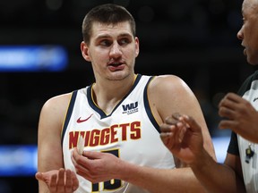 Denver Nuggets center Nikola Jokic, left, argues for a call with referee Kevin Cutler in the first half of an NBA basketball game against the Golden State Warriors, Tuesday, Jan. 15, 2019, in Denver.