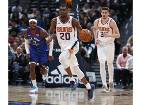 Phoenix Suns forward Josh Jackson, front, drives upcourt as Denver Nuggets forward Paul Millsap, back left, and Suns forward Dragan Bender follow in the first half of an NBA basketball game Friday, Jan. 25, 2019, in Denver.