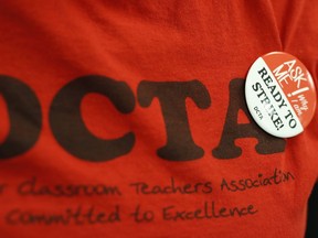 FILE - In this Thursday, Jan. 17, 2019, file photograph, a teacher wears a button on a union shirt in the Denver Classroom Teachers Association, the union's headquarters in south Denver. Teachers voted Tuesday, Jan. 22, 2019, to authorize a strike, which would be the first called in 25 years in the state's largest school district.