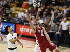 Washington State forward Jeff Pollard, front, drives to the rim for a basket past Colorado guard Daylen Kountz, back left, and guard Tyler Bey in the first half of an NCAA college basketball game Thursday, Jan. 10, 2019.