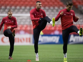 Canadian men's national soccer team players Samuel Piette, from left, Marcus Haber and Adam Straith stretch during practice in Vancouver, B.C., on Thursday November 12, 2015. Pacific FC, Victoria's entry in the new Canadian Premier League, has signed Canadian international striker Marcus Haber.