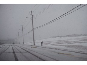 A pedestrian walks through blizzard-like conditions in Halifax as heavy snow, high winds and pounding surf hit most of Atlantic Canada on Tuesday, March 13, 2018. Halifax has become the second Canadian city to declare a climate emergency. Council voted Tuesday to pass a mostly symbolic acknowledgment that climate change is a serious and urgent threat.THE CANADIAN PRESS/Darren Calabrese