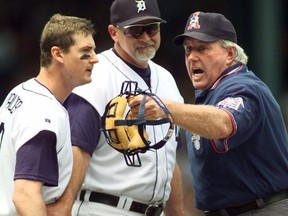 Detroit Tigers' Dean Palmer, left, continues to argue with home plate umpire Jim McKean, right, as manager Larry Parrish holds Palmer back in the second inning of their game with Kansas City Thursday, July 22, 1999, in Detroit. McKean, the long-time MLB umpire and former CFL player has died at age 73.