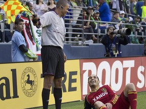 Real Salt Lake's Fabian Espindola, right, jokes with Referee's Assistant Joe Fletcher during the second half of play in a MLS soccer match in Seattle on May 12, 2012. After two World Cups and numerous other big matches, Canada's Joe Fletcher is retiring as an assistant referee. The 42-year-old Fletcher, from St. Catharines, Ont., by way of Niagara Falls, says the time is right. He leaves at the top of his game, having been named MLS assistant referee of the year in 2018.