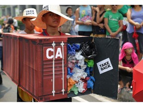 More than 100 community and environment groups in the Philippines are making a plea to Prime Minister Justin Trudeau to take out Canada's trash. Filipino environmental activists wear a mock shipping container filled with garbage to symbolize the 50 containers of waste that were shipped from Canada to the Philippines in 2013 and 2014, as they hold a protest outside the Canadian embassy in Makati, metro Manila, Philippines, on Thursday, May 7, 2015.