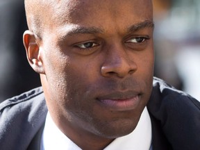 RCMP Const. Kwesi Millington leaves court during a lunch break at his perjury trial in Vancouver on March 10, 2014. A former Mountie involved in the death of a man jolted by a Taser at Vancouver's airport is suing the federal and provincial governments for damages, claiming he acted in accordance with RCMP training. Kwesi Millington was in charge of the Taser when he and three other Mounties approached a troubled Robert Dziekanski in 2007.