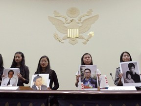 From left, Lisa Peng, holding a photo of her father Peng Ming, Grace Ge Geng, holding photo of her father Gao Zhisheng, Ti-Anna Wang, holding photo of her father Wang Bingzhang, Bridgette Chen holding photo of her father Liu Xianbing, and Danielle Wang, holding photo of her father Wang Zhiwen, are introduced prior to testifying before the House Foreign Affairs Committee hearing entitled, "Their Daughters Appeal to Beijing: 'Let Our Fathers Go,! on Capitol Hill in Washington, Thursday, Dec. 5, 2013. Ti-Anna Wang was one passport stamp away from seeing her imprisoned father in a Chinese prison before her dream was shattered yet again.