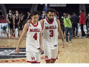 McGill Redmen's Jenning Leung, left, and Dele Ogundokun walk off the court after losing to the Carleton Ravens in the bronze medal game of the U Sports men's basketball national championship in Halifax on March 11, 2018.