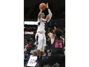 Connecticut's Alterique Gilbert, top, shoots over SMU's Ethan Chargois during the first half of an NCAA college basketball game, Thursday, Jan. 10, 2019, in Storrs, Conn.