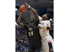 CORRECTS DATE - Connecticut's Eric Cobb, right, fouls Central Florida's Tacko Fall during the first half of an NCAA college basketball game, Saturday, Jan. 5, 2019, in Hartford, Conn.