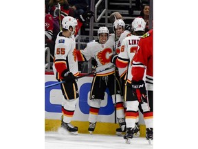 Calgary Flames left wing Johnny Gaudreau, second from left, celebrates with teammates after scoring a goal past Chicago Blackhawks goaltender Collin Delia during the first period of an NHL hockey game on Monday Jan. 7, 2019, in Chicago.