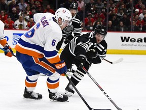 New York Islanders defenseman Ryan Pulock (6) fights for the puck against Chicago Blackhawks left wing Chris Kunitz (14) during the first period of an NHL hockey game on Tuesday Jan. 22, 2019, in Chicago.