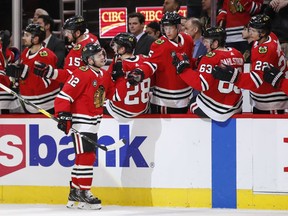 Chicago Blackhawks left wing Alex DeBrincat celebrates with teammates after scoring against the Nashville Predators during the first period of an NHL hockey game Wednesday, Jan. 9, 2019, in Chicago.