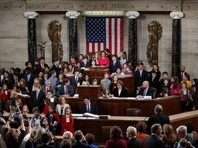 Nancy Pelosi of California, surrounded by her grandchildren and other children raises her right hand as Rep. Don Young, R-Alaska, the longest-serving member of the House, administers the oath to Pelosi to become the Speaker of the House at the Capitol in Washington, Thursday, Jan. 3, 2019.