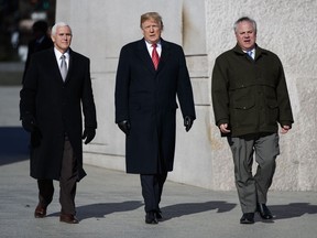 President Donald Trump, center, Vice President Mike Pence, left, escorted by Acting Interior Secretary David Bernhardt, right, visit the Martin Luther King Jr. Memorial, Monday, Jan. 21, 2019, in Washington.