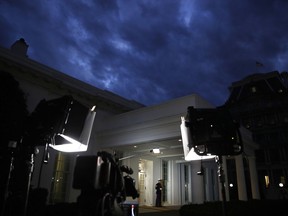A Marine stands by the door to the West Wing of the White House, Tuesday Jan. 8, 2019, in Washington, as television lights are at the ready a few hours before President Donald Trump is expected to make an address to the nation.
