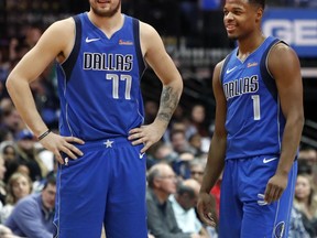Dallas Mavericks Luka Doncic (77) of Germany and teammate Dennis Smith Jr. (1) share a laugh during the first half of an NBA basketball game against the LA Clippers in Dallas, Tuesday, Jan. 22, 2019.