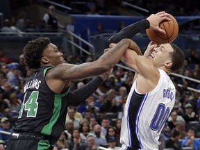 Boston Celtics' Robert Williams, left, fouls Orlando Magic's Aaron Gordon as he goes up for a shot during the first half of an NBA basketball game, Saturday, Jan. 12, 2019, in Orlando, Fla.